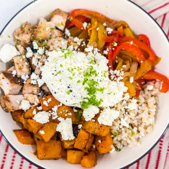 Butternut Squash Fajita Bowl - Roasted butternut squash, bell peppers, caramelized onions, and fajita-spiced chicken over brown rice, finished with lime crema, cotija