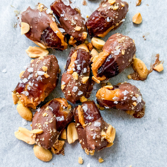 Date Snickers - Date stuffed with peanut buttered drizzled with chocolate and topped with chocolate peanuts and sea salt