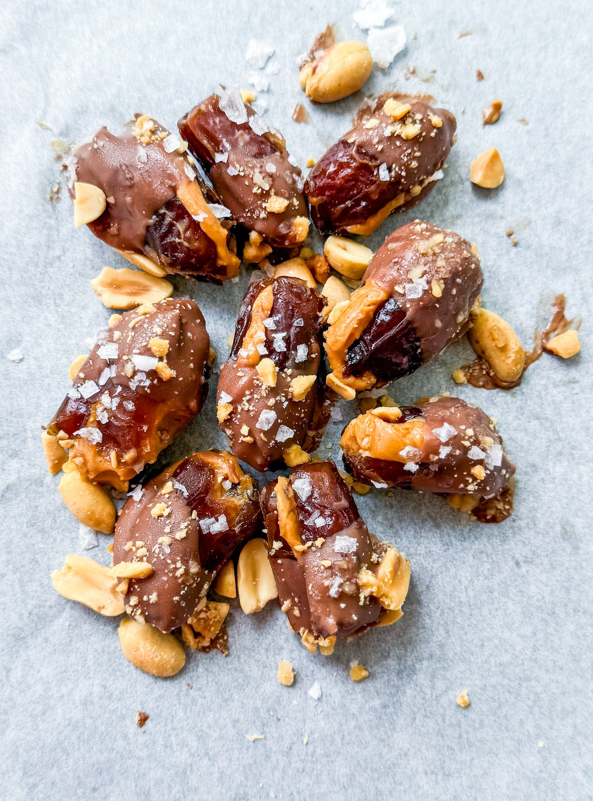 Date Snickers - Date stuffed with peanut buttered drizzled with chocolate and topped with chocolate peanuts and sea salt