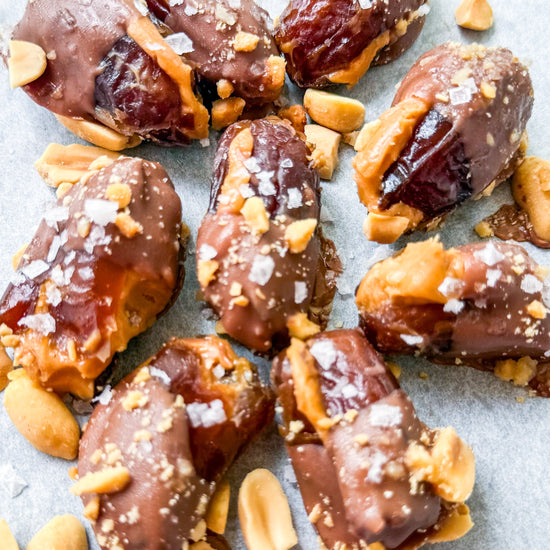 Date Snickers - Date stuffed with peanut buttered drizzled with chocolate and topped with chocolate peanuts and sea salt