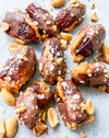 Date Snickers - Date stuffed with peanut buttered drizzled with chocolate and topped with chocolate peanuts and sea salt