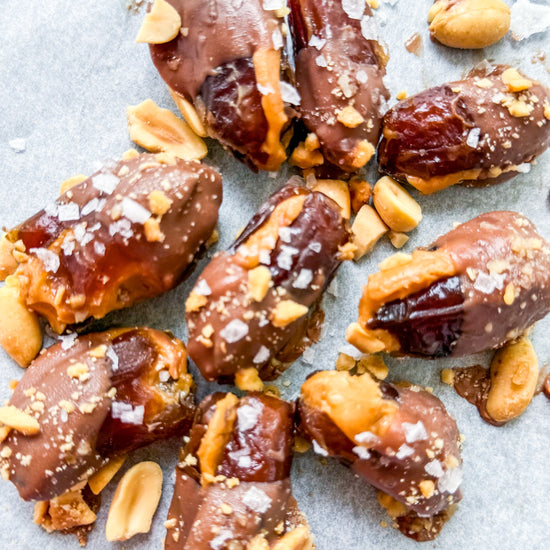 Date Snickers - Date stuffed with peanut buttered drizzled with chocolate and topped with chocolate peanuts and sea salt