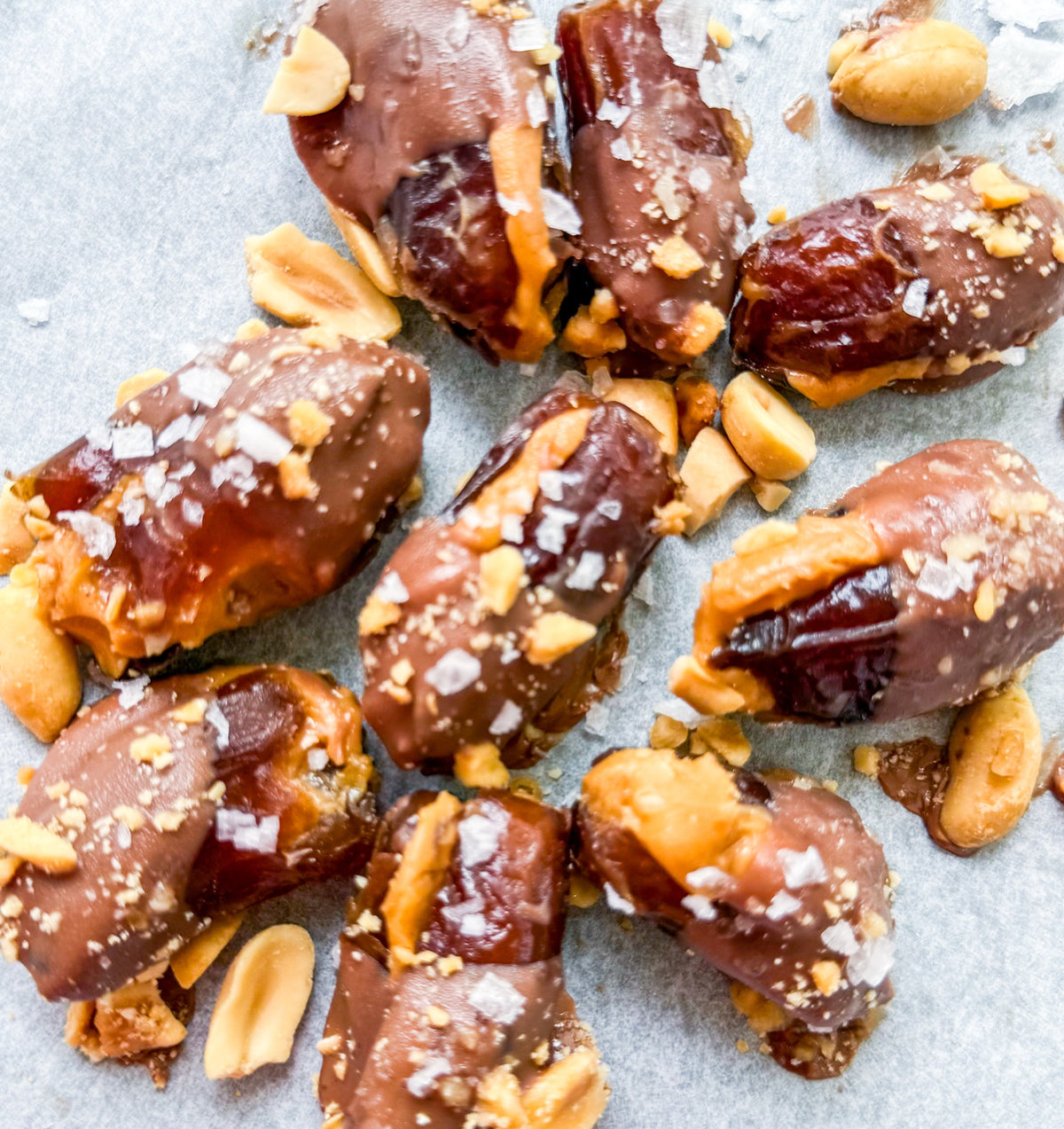 Date Snickers - Date stuffed with peanut buttered drizzled with chocolate and topped with chocolate peanuts and sea salt