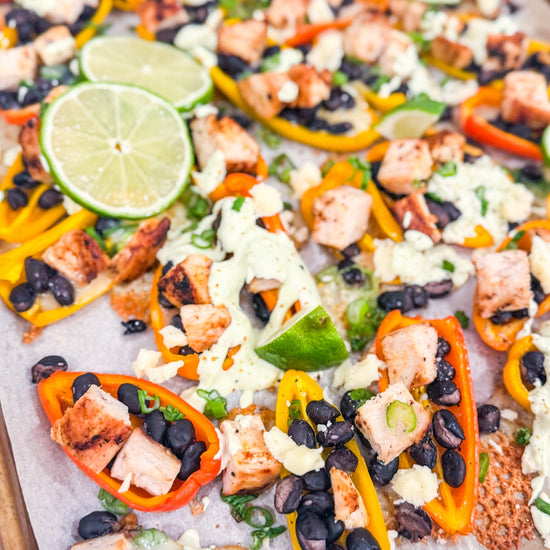 Eat Fit Pepper Nachos - Mini sweet peppers topped with chili-lime chicken, black beans, white cheddar, and green onions, finished with avocado sour cream and fresh lime