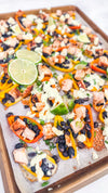 Eat Fit Pepper Nachos - Mini sweet peppers topped with chili-lime chicken, black beans, white cheddar, and green onions, finished with avocado sour cream and fresh lime