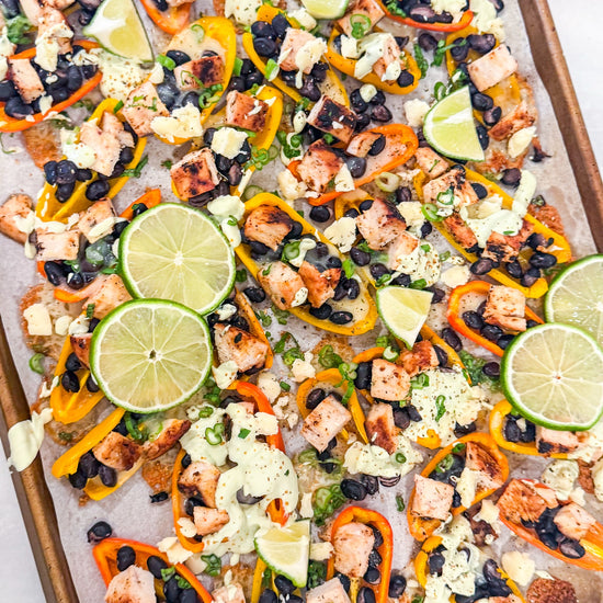 Eat Fit Pepper Nachos - Mini sweet peppers topped with chili-lime chicken, black beans, white cheddar, and green onions, finished with avocado sour cream and fresh lime