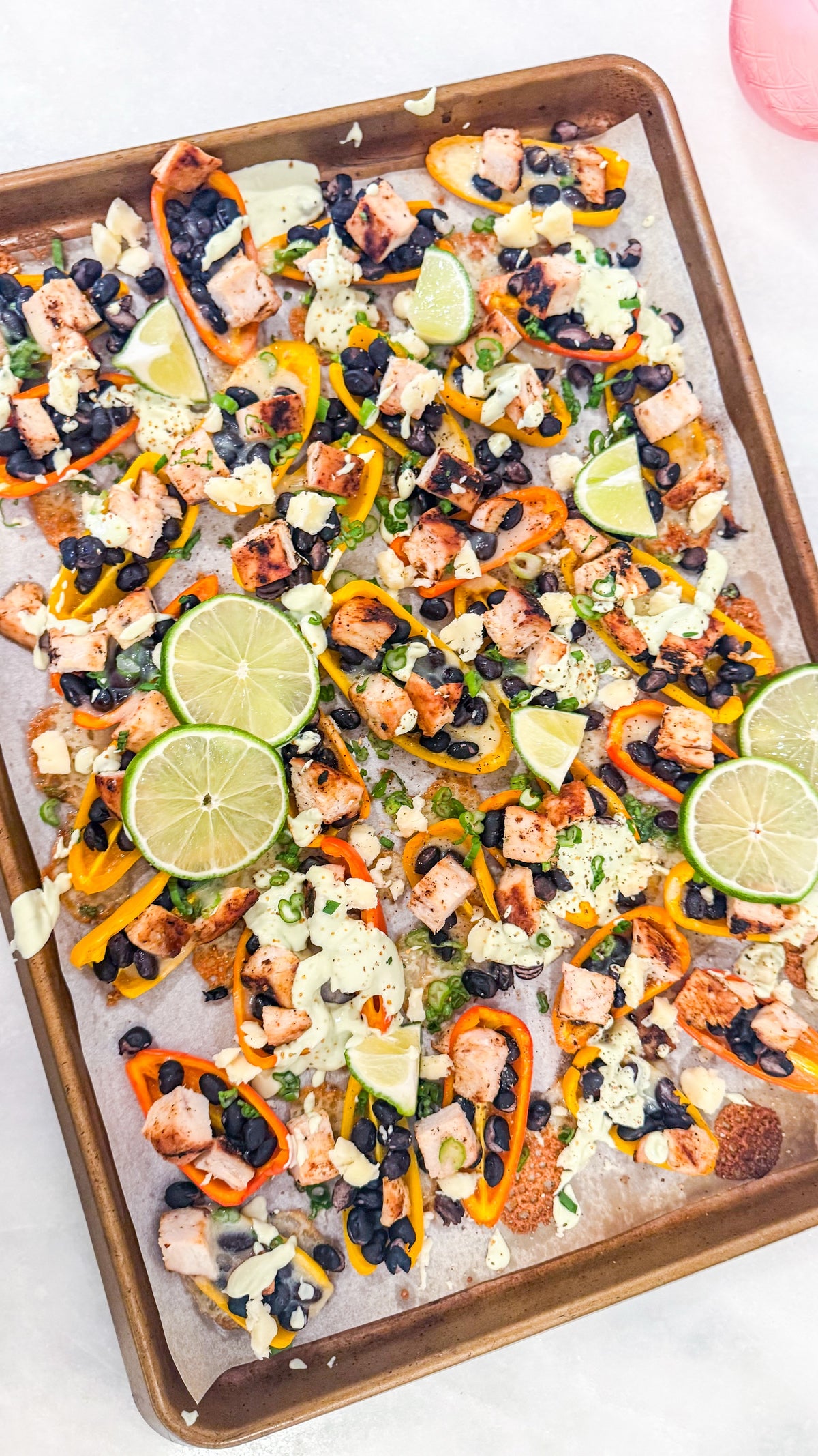 Eat Fit Pepper Nachos - Mini sweet peppers topped with chili-lime chicken, black beans, white cheddar, and green onions, finished with avocado sour cream and fresh lime
