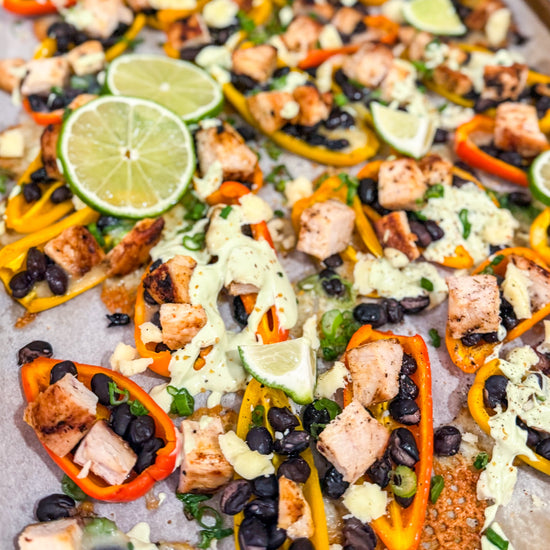 Eat Fit Pepper Nachos - Mini sweet peppers topped with chili-lime chicken, black beans, white cheddar, and green onions, finished with avocado sour cream and fresh lime