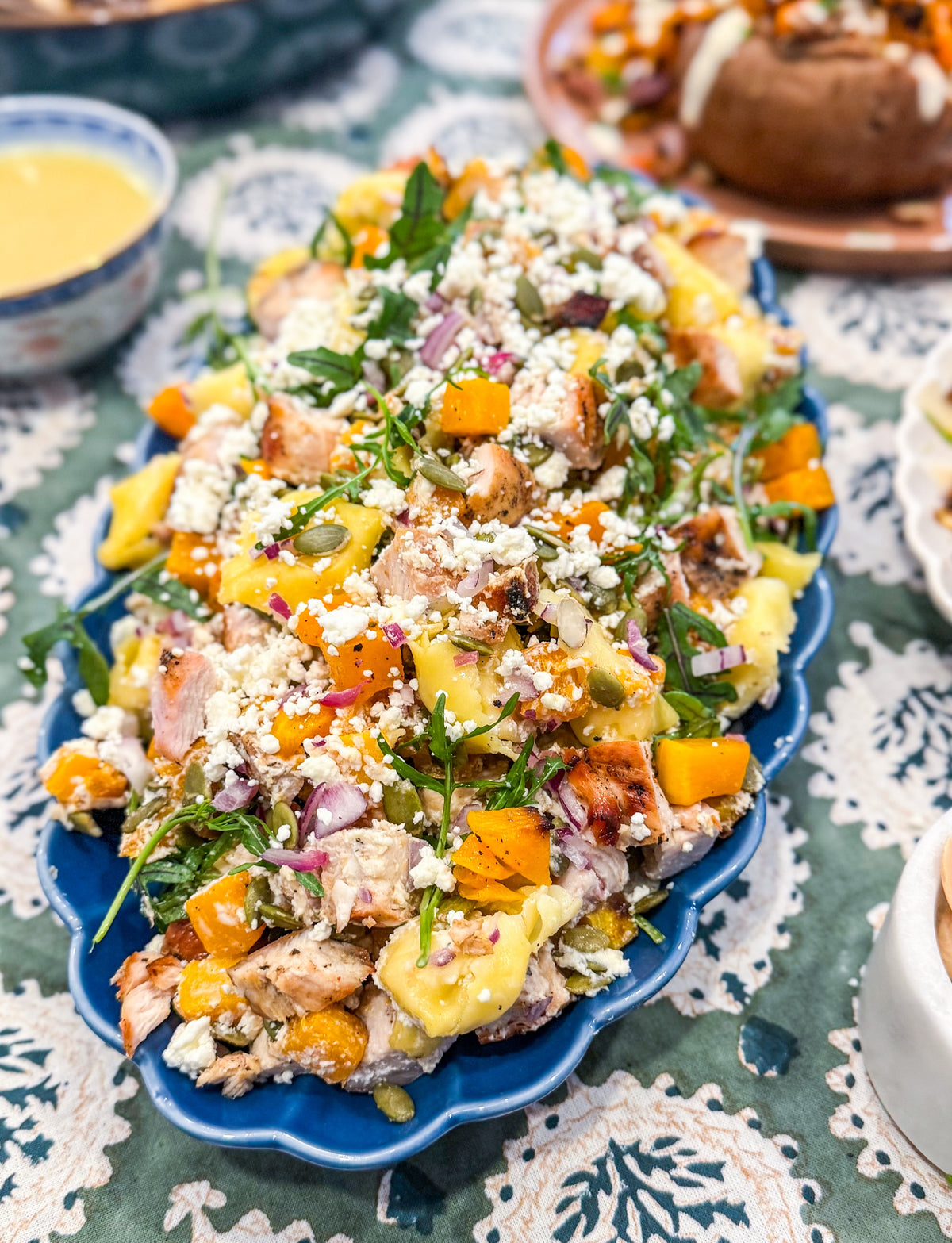 Roasted Squash Pasta Salad - Roasted squash, pepitas, and goat cheese combined with grilled chicken, shallots, baby arugula, and tender tortellini, all tossed in a rich brown butter vinaigrette.