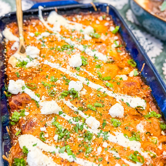 Chicken &amp; Butternut Squash Enchilada Bake - Tender chicken, roasted butternut squash, Mexican cheese and golden enchilada sauce wrapped in tortillas and topped with crumbly cotija cheese and herb crema