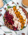 Harvest Cobb - Cider-brined grilled chicken, mixed greens, roasted butternut squash, dried cranberries, spiced pecans, goat cheese, bacon, and maple-Dijon dressing